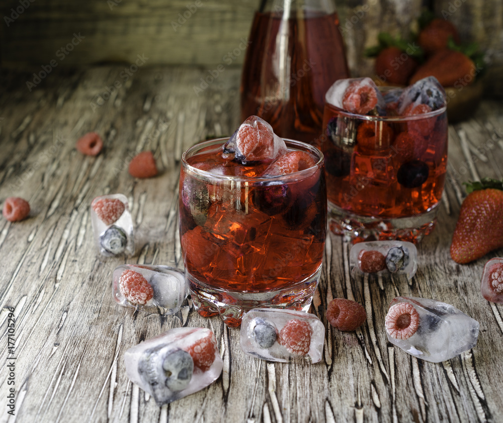 Summer berry lemonade with frozen berries on a wooden rustic table, selective focus Summer berry lemonade with frozen berries on a wooden rustic table, selective focus
