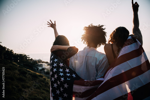 Group of millennial friends holding USA flag