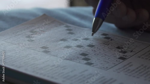 Close Up of Hands Making Crossword Puzzle