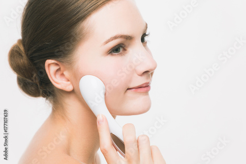 woman using handy ion introduction instrument. skincare concept. photo