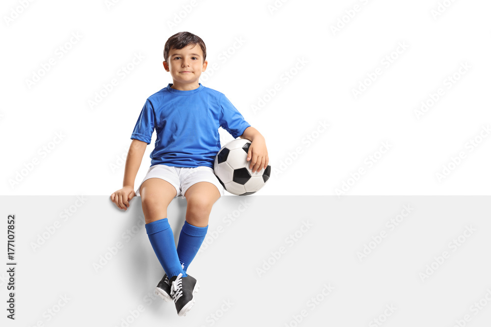 Little footballer sitting on a panel