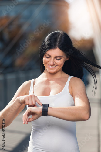 City workout. Beautiful woman with a smartwatch training in an urban setting