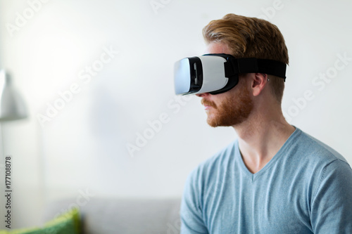 Man wearing virtual reality headset at home