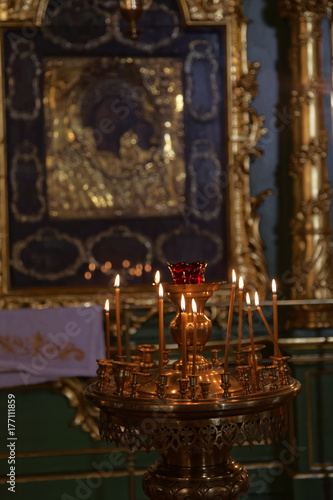 Many burning wax candles in the orthodox church