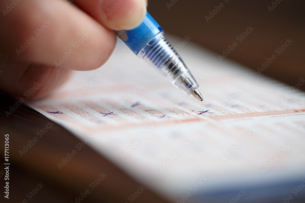 Picture of person marking in lottery ticket Picture of person marking in lottery ticket