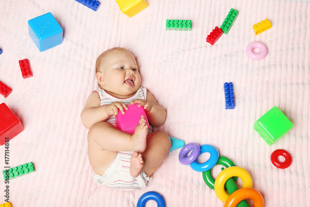 Little newborn baby with toys on pink bed Little newborn baby with toys on pink bed