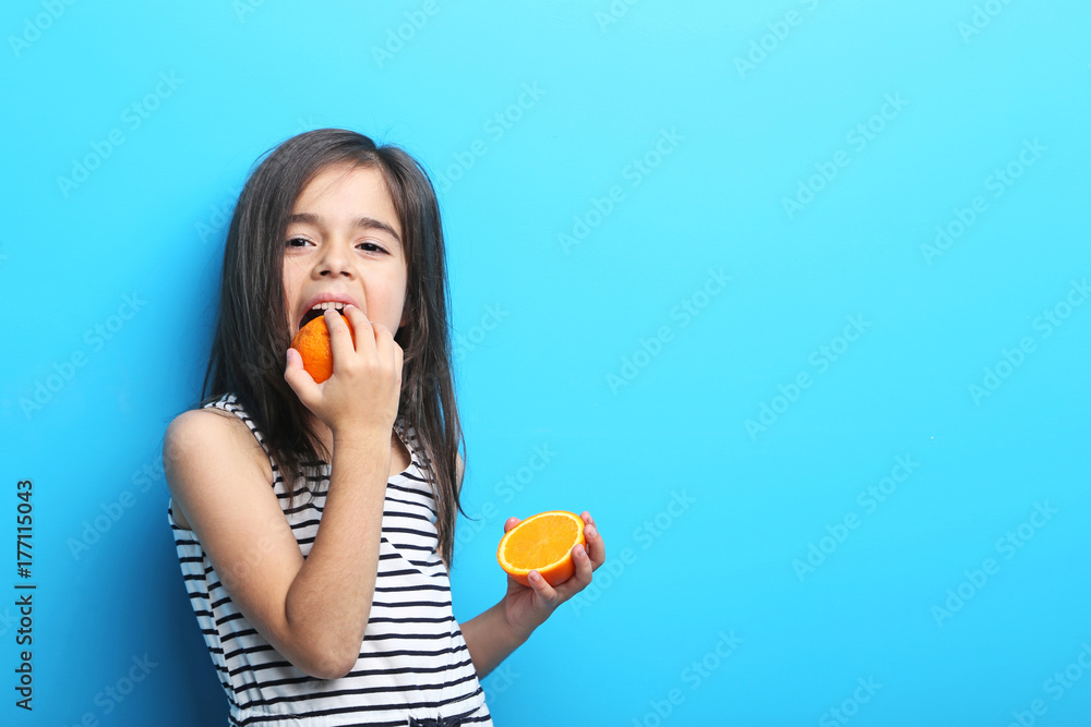 Beautiful little girl with orange on blue background Beautiful little girl with orange on blue background