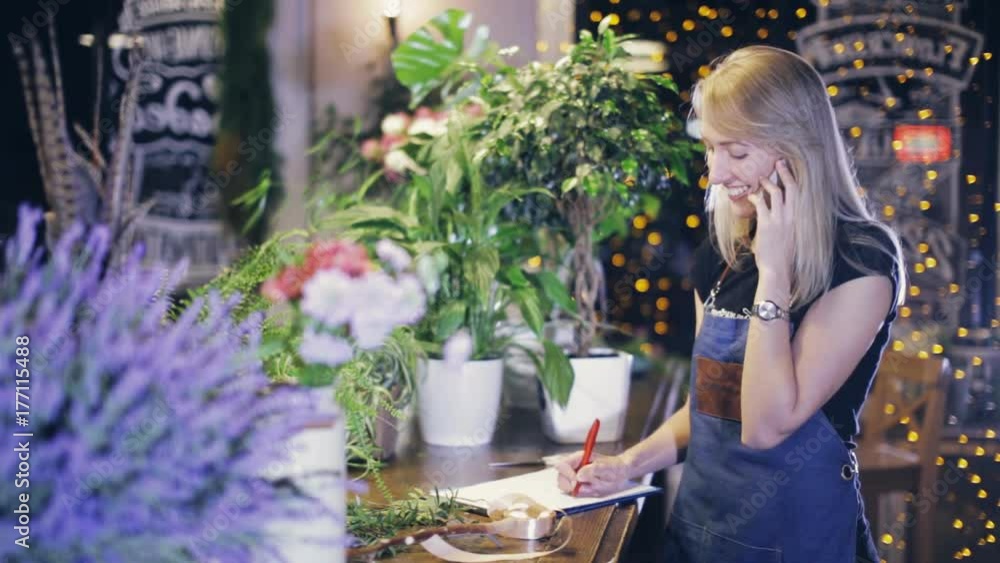 female florist on the phone orders flowers from the supplier female florist on the phone orders flowers from the supplier