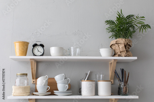 Utensils and mugs on shelf