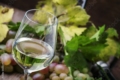 Bilde på lerret Dry white wine and grapes, vintage wooden background, selective focus
