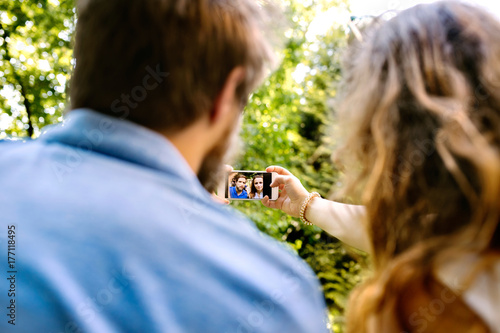 Young couple with smartphone taking selfie.