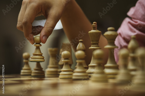 on a chess game, a chess player makes a move with a pawn