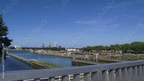 Skyline city of Maasbracht + inland port + pan higher situated Lock complex with video surveillance. LOCK COMPLEX MAASBRACHT, THE NETHERLANDS - AUGUST 2015 photo