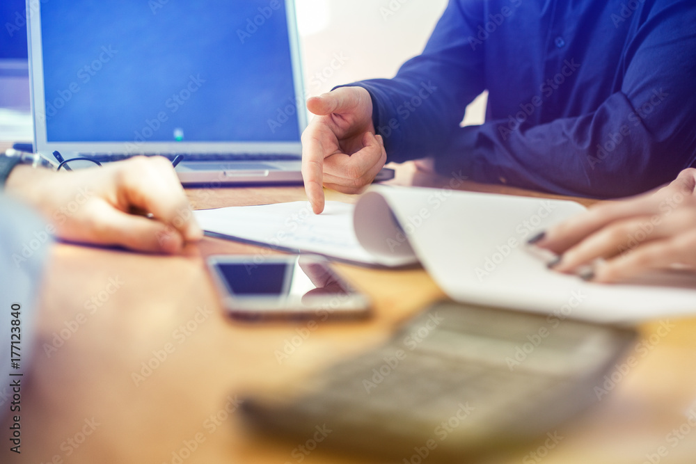 Anonymous Business Meeting with diagram, charts, laptop smartphone and hands, selective focus: finger poiting something out Anonymous Business Meeting with diagram, charts, laptop smartphone and hands, selective focus: finger poiting something out