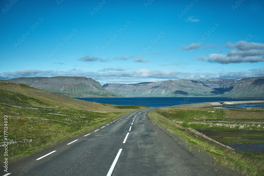 Travel to Iceland. plot of asphalt road in a bright sunny mountain landscape. focus on the road