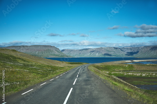 Travel to Iceland. plot of asphalt road in a bright sunny mountain landscape. focus on the road