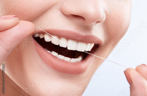 Teeth cleaning with tooth thread and smiling