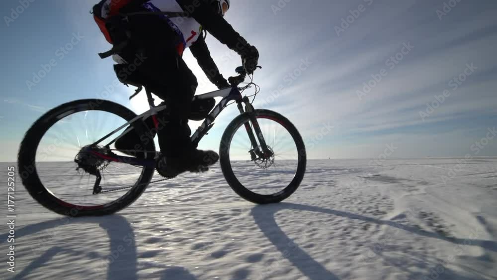 a man riding a bicycle across a frozen lake a man riding a bicycle across a frozen lake