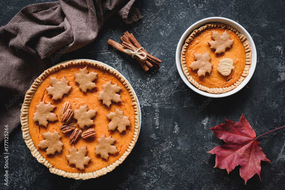 Pumpkin pies with pecan nuts on stone background. Table top view Pumpkin pies with pecan nuts on stone background. Table top view