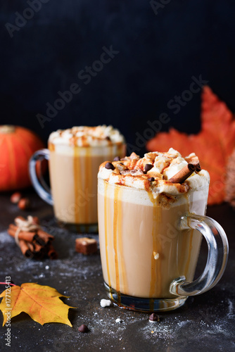Pumpkin Caramel Spice Latte with marshmallows, caramel syrup and chocolate bars. Closeup view, vertical