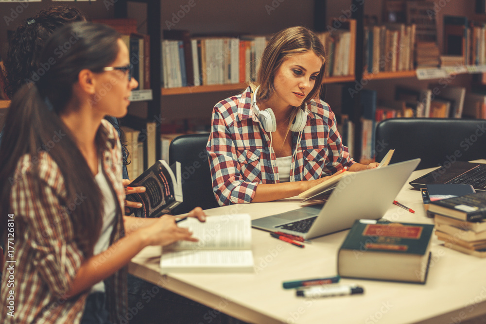 Group of female students study in the school library.Learning and preparing for university exam. Group of female students study in the school library.Learning and preparing for university exam.