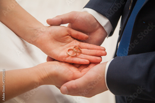 the bride and groom hold wedding rings