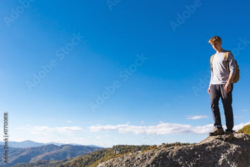 Man walking on the edge of a cliff high above the mountains