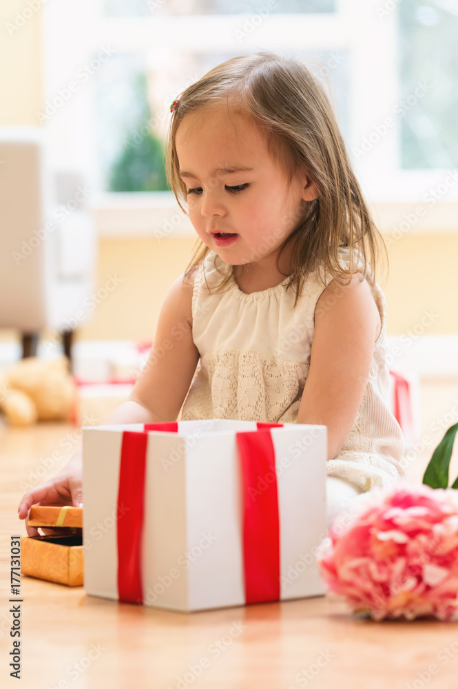 Little girl opening a Christmas present box Little girl opening a Christmas present box
