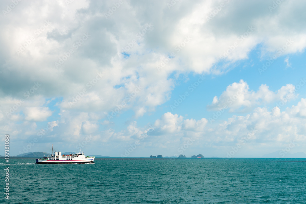 White ferry in seascape with green islands on horizon