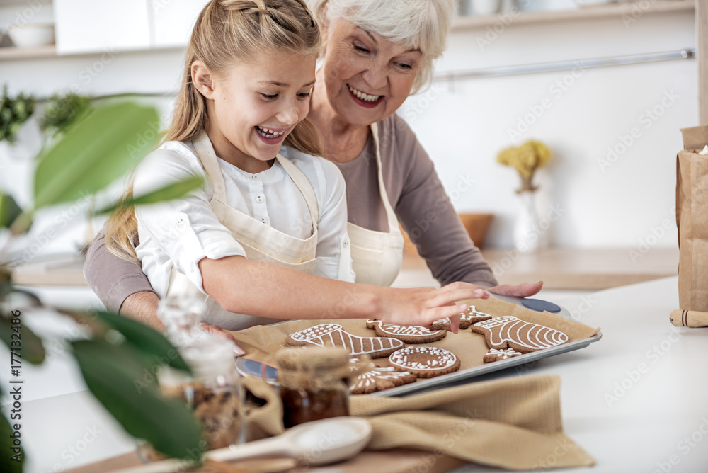 Joyful old woman giving sweet pastry to kid Stock Photo | Adobe Stock