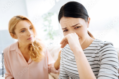 Cheerless unhappy woman wiping her nose