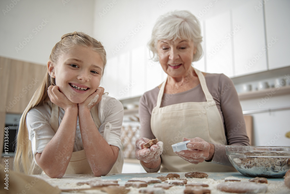 Carefree child enjoying cooking with her grandmother Carefree child enjoying cooking with her grandmother