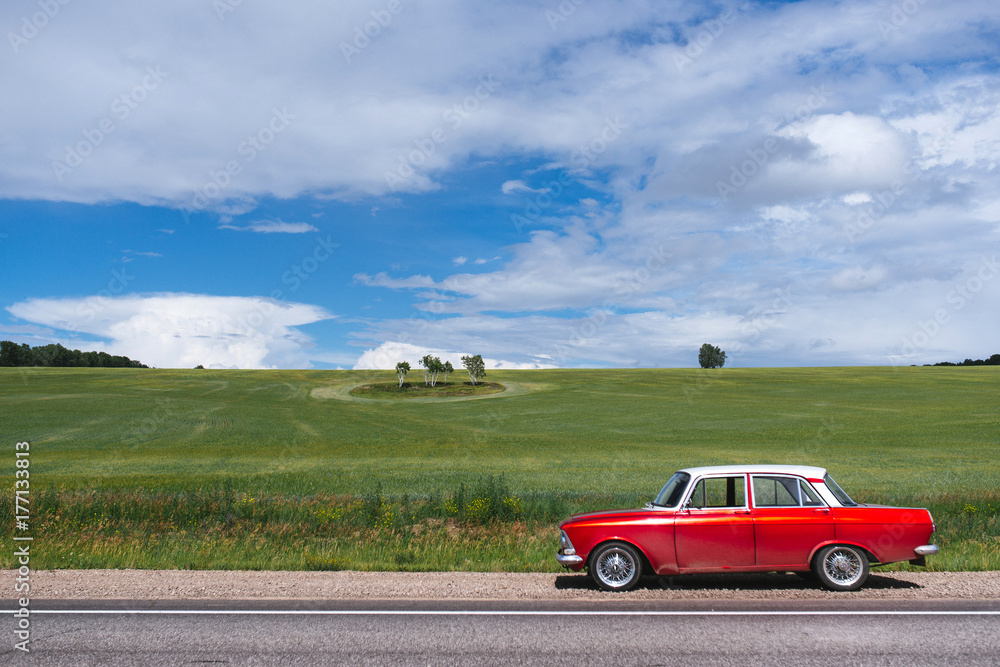 Fototapeta premium Retro car. The red-and-white car. In the field.