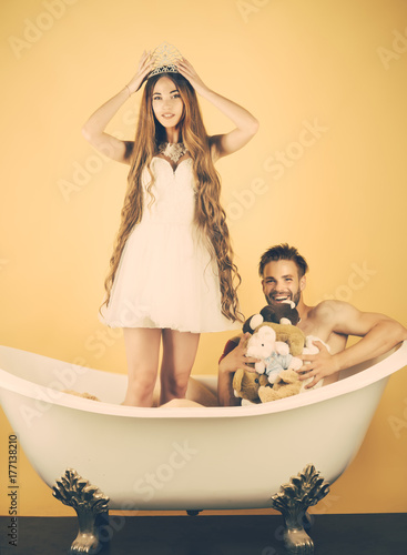 Man in bathtub near girl with long hair.