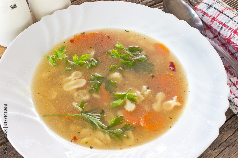 Soup with meatballs and pasta in plate on table Soup with meatballs and pasta in plate on table