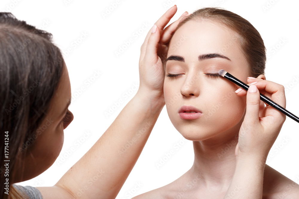 Applying female makeup, isolated on white Applying female makeup, isolated on white