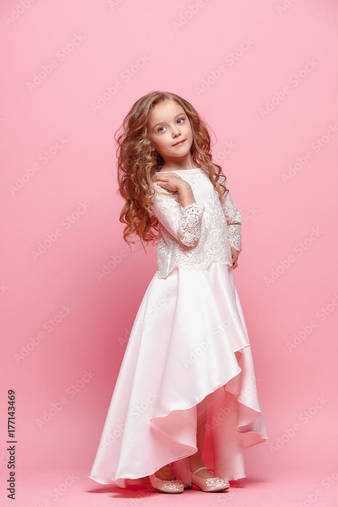 Full length of beautiful little girl in dress standing and posing over white background Full length of beautiful little girl in dress standing and posing over white background