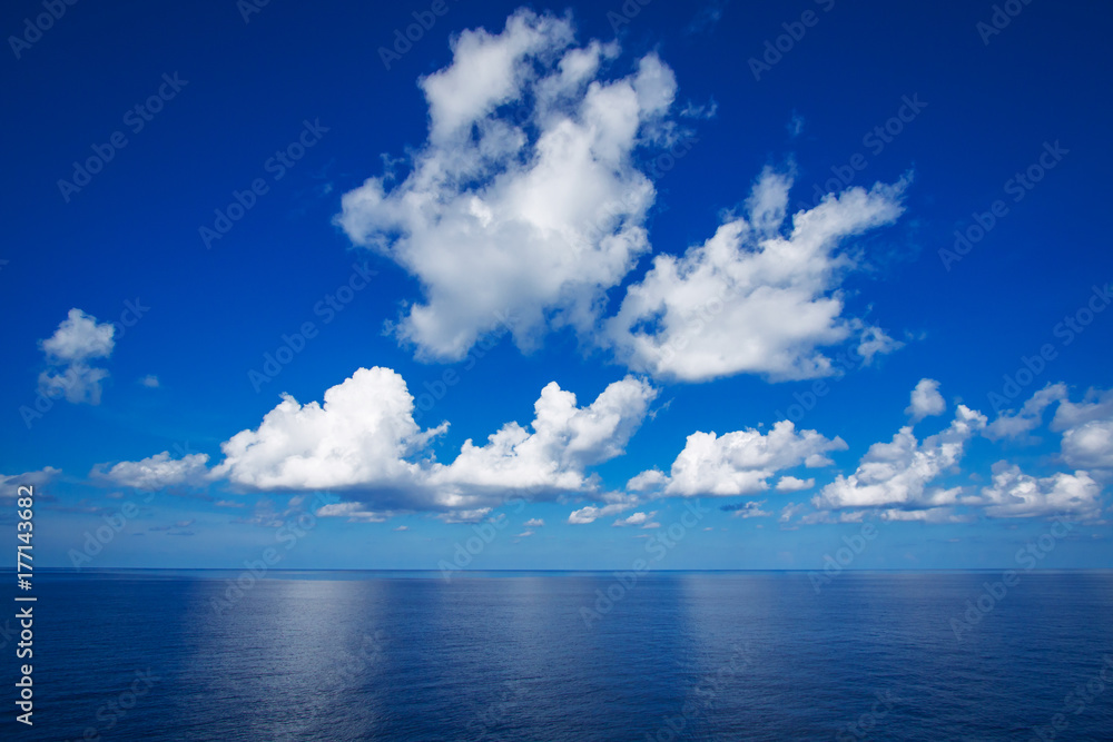 Blue sky with white clouds reflex on the sea.