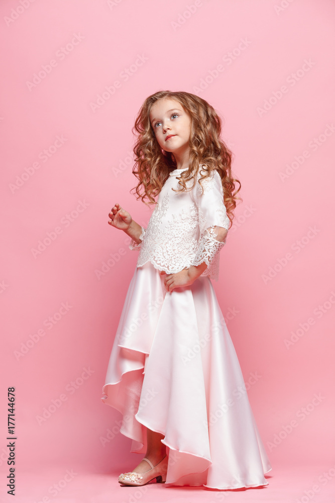 Full length of beautiful little girl in dress standing and posing over white background Full length of beautiful little girl in dress standing and posing over white background