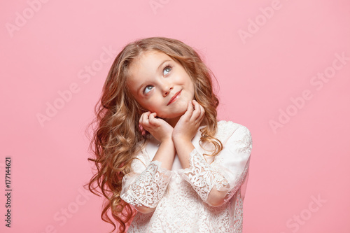Konstfotografi The beautiful little girl in dress standing and posing over white background
