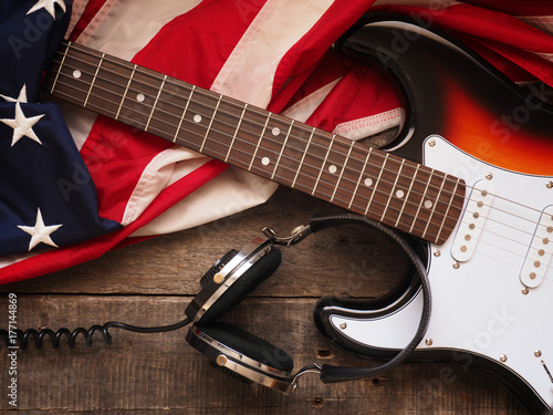 Old used guitar with headphones and American flag