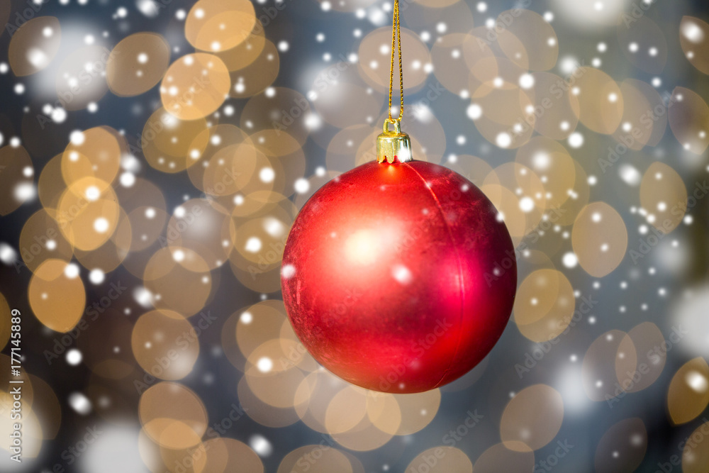 close up of red christmas ball over golden lights close up of red christmas ball over golden lights