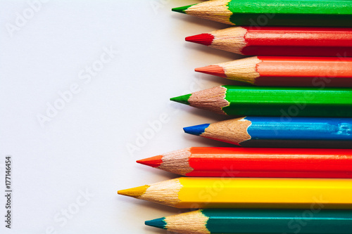 Colorful pencils on white sheet of paper photo