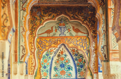 Old naive fresco with birds and floral patterns on historical home columns, India