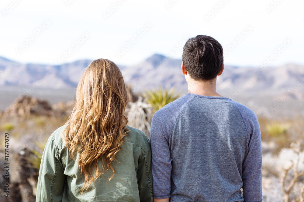Couple facing away from the camera in desert Couple facing away from the camera in desert