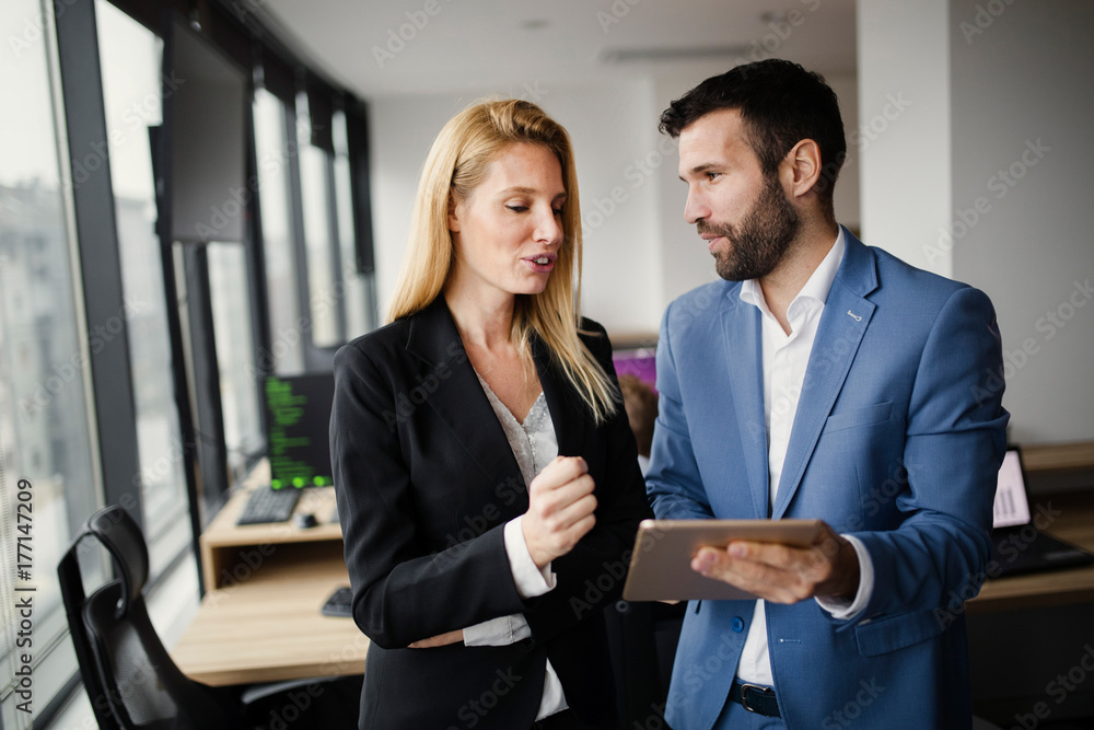 Portrait of attractive business partners using tablet