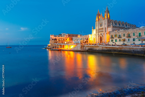 Balluta Bay and Neo-Gothic Church of Our Lady of Mount Carmel, Balluta parish church, during evening blue hour, Saint Julien, Malta