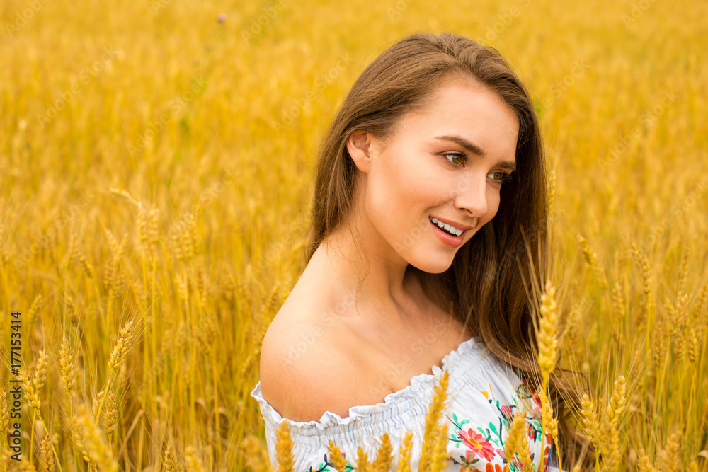 Young woman on a background of golden wheat field Young woman on a background of golden wheat field