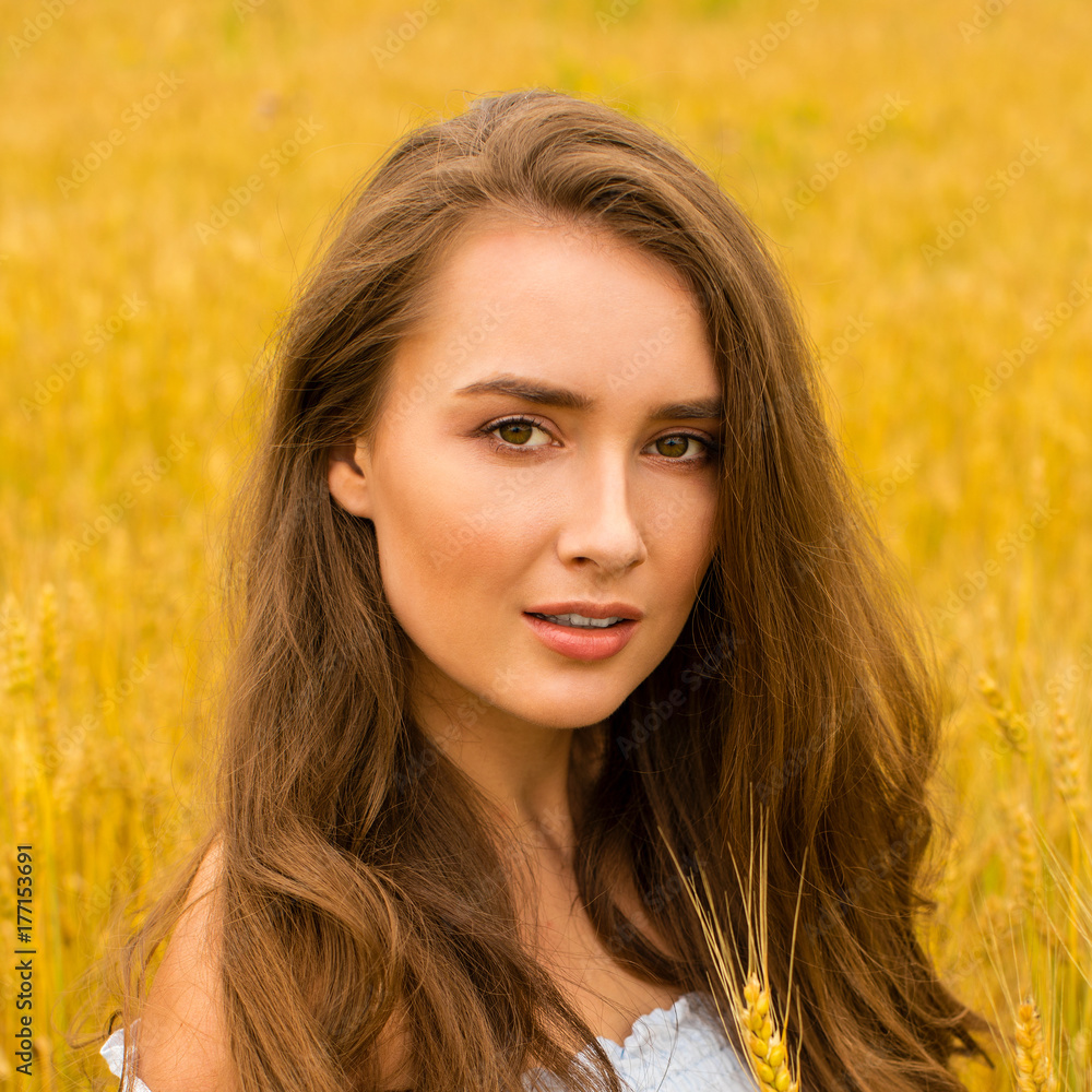 Young woman on a background of golden wheat field Young woman on a background of golden wheat field