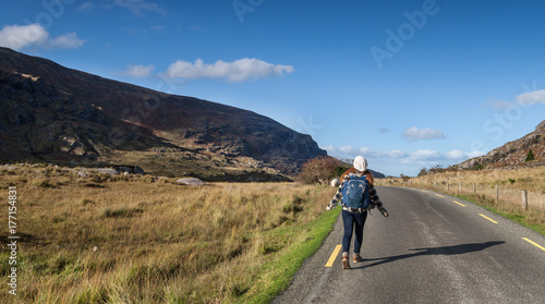 Woman hiker walking through the wild scenic landscape of the Gap of Dunloe in county Kerry, Ireland